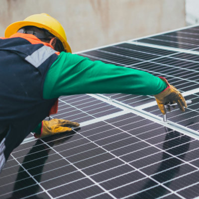 worker servicing solar panel